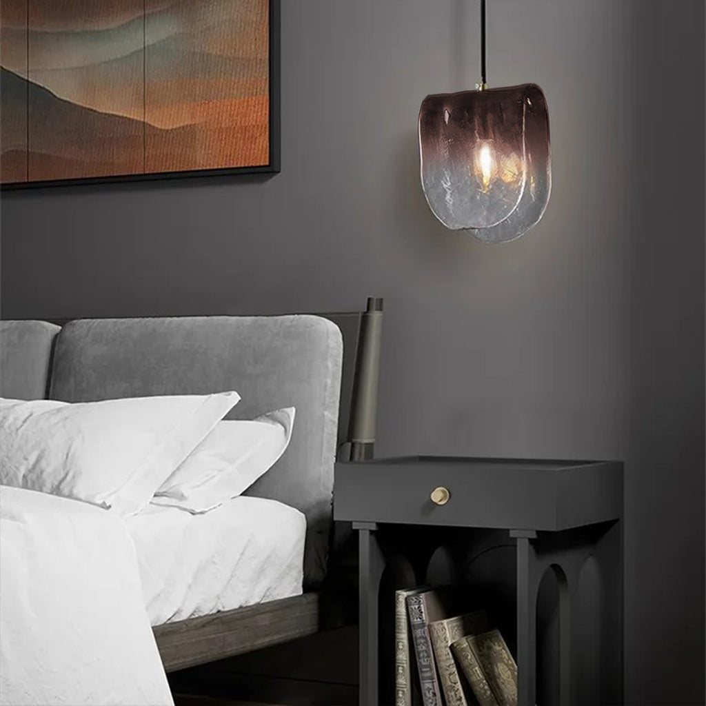 Modern pendant light with a glass shade on a dark background