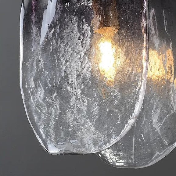 Close-up of a textured glass light fixture with a warm glow on a dark background