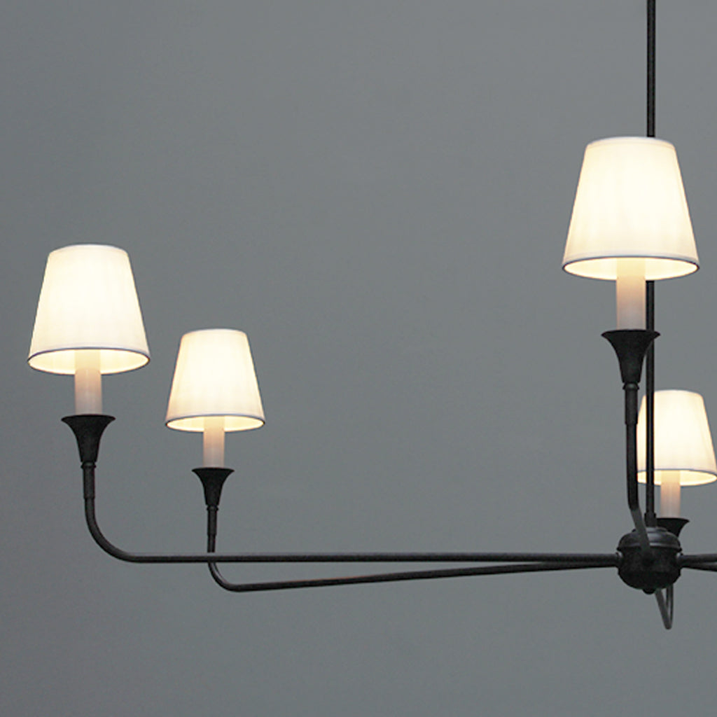 Chandelier with four white lampshades on a gray background