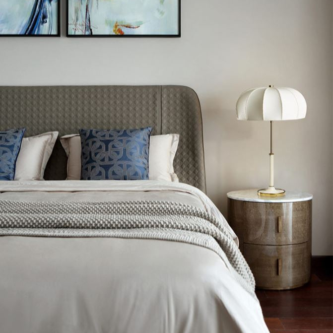Modern bedroom with a bed, nightstand, and decorative pillows.