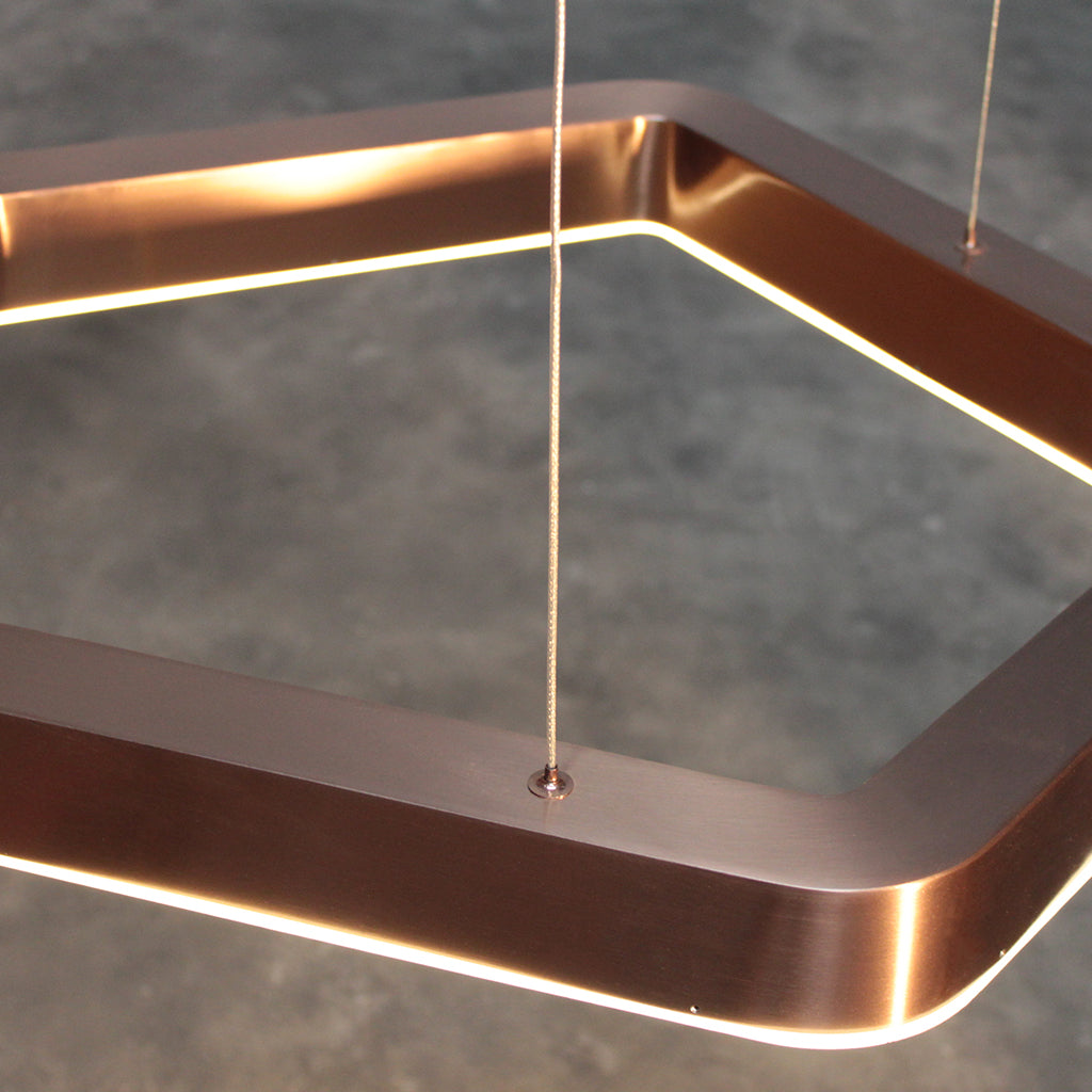 Modern pendant light with copper finish on a blurred background