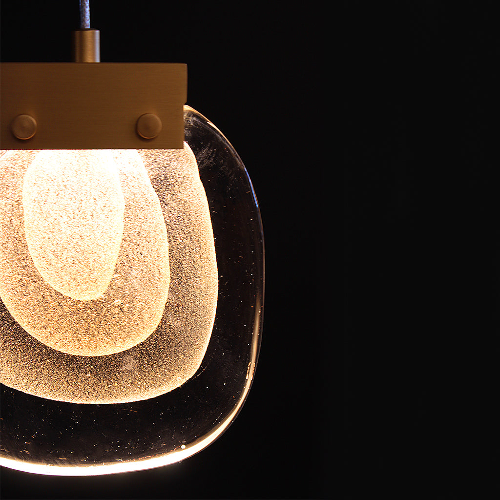 Pendant light with a textured glass shade on a black background