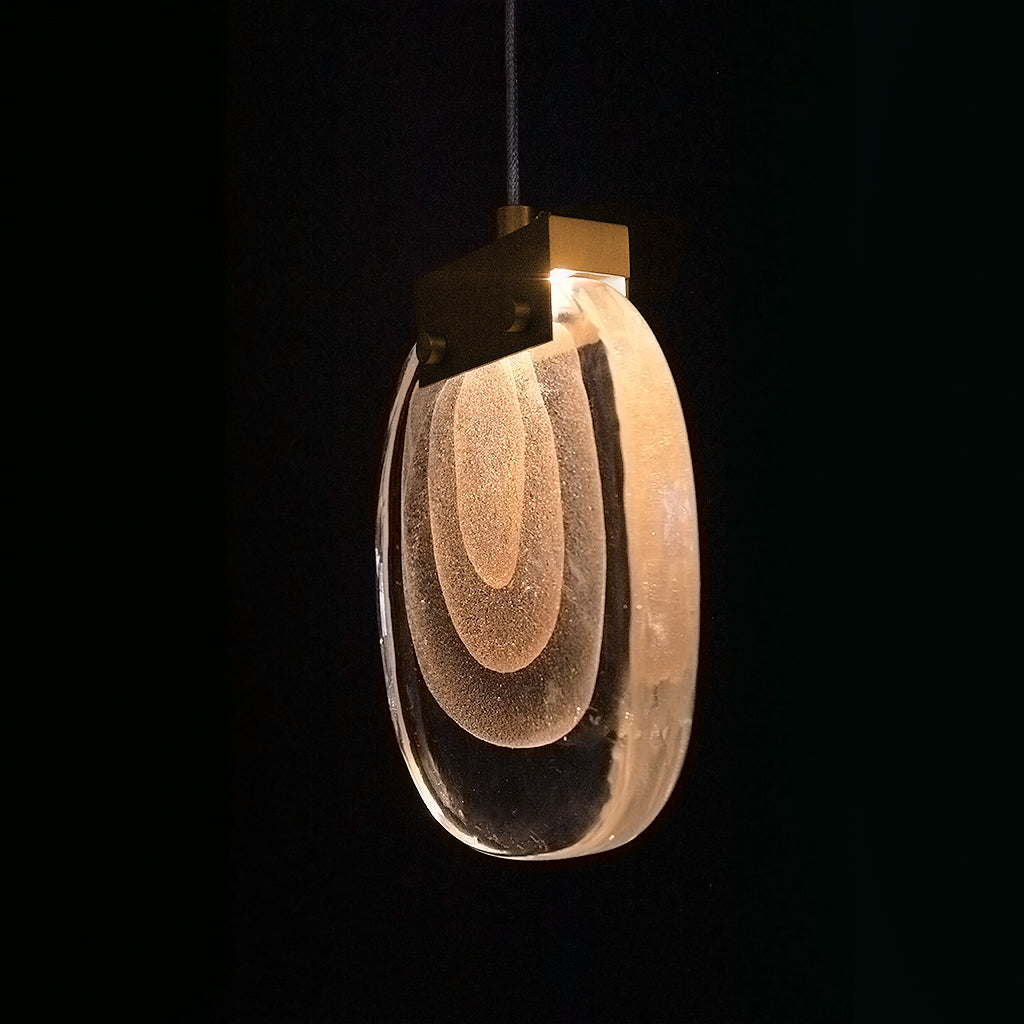 Modern pendant light with a glass shade on a black background