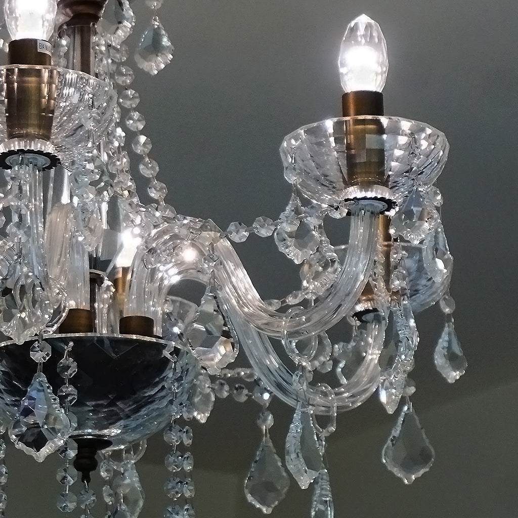 Close-up of a crystal chandelier with clear crystal and brass fixtures.