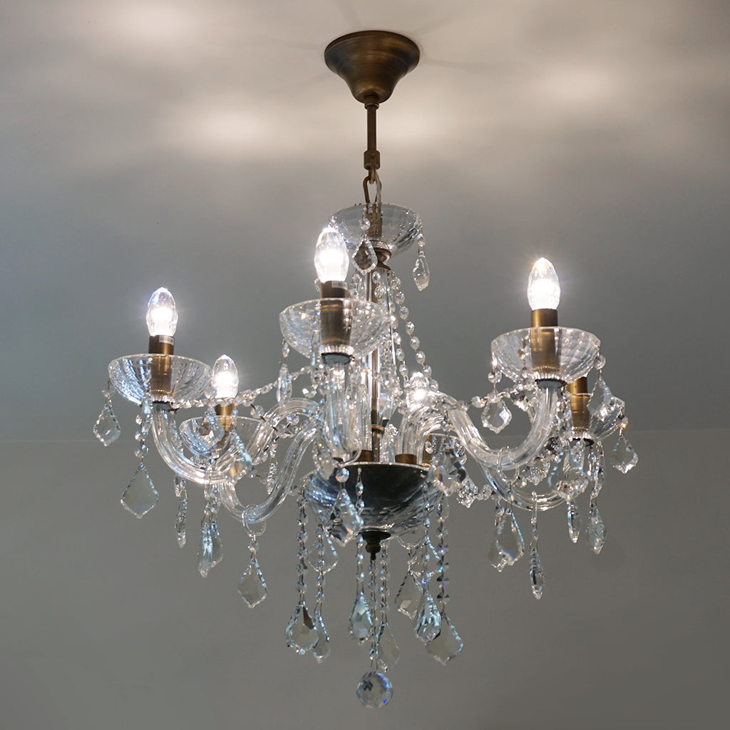 Crystal chandelier with multiple lights on a gray background