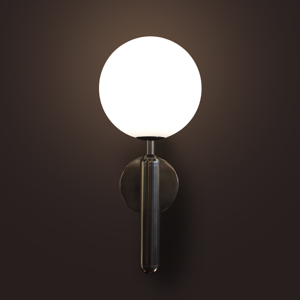 Modern wall lamp with a round white shade and black metallic base on a dark background