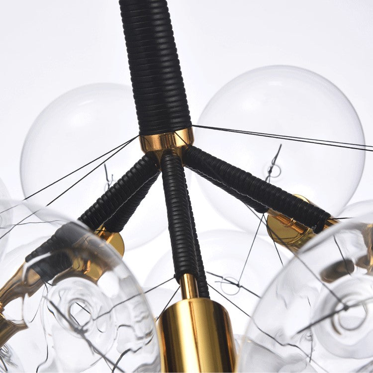Modern chandelier with clear glass bubbles and gold accents on a white background