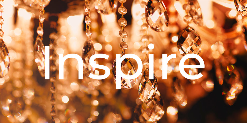 Decorative text 'Inspire' with sparkling gold and crystal elements on a blurred background.