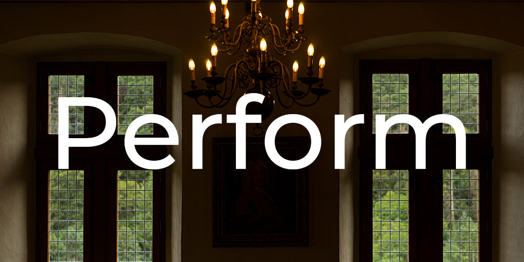Chandelier hanging above a room with large windows, text overlay 'Perform'.