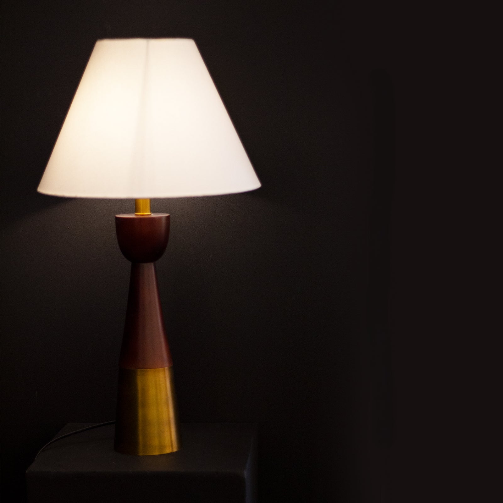 Table lamp with a brown and gold base on a dark background