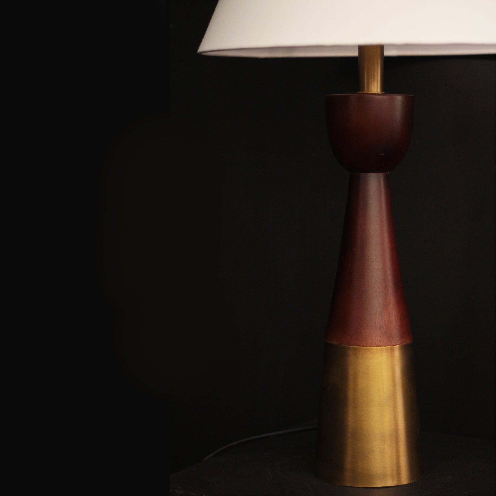 Table lamp with a brown and gold base on a dark background