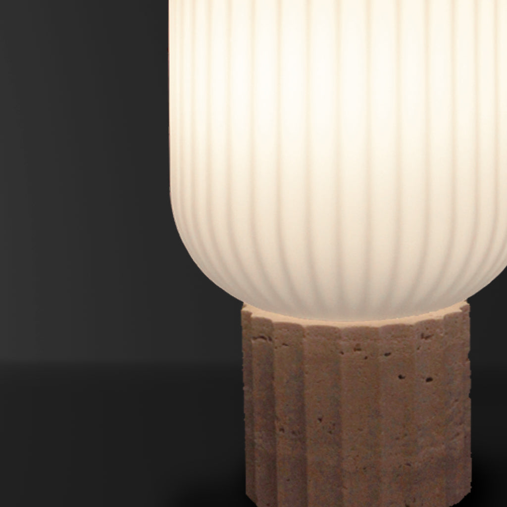 Table lamp with ribbed glass shade and stone base on a dark background