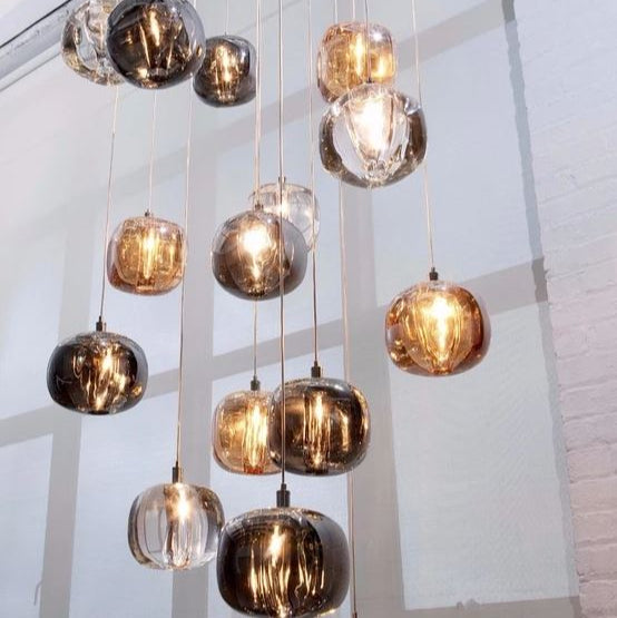 A group of Rocas pendant lights made of solid crystal with chrome fittings, hanging in a cluster to provide minimalist contemporary lighting.