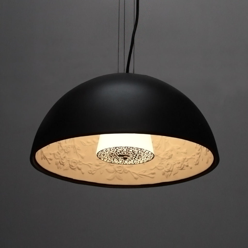 Black pendant light with textured interior on a dark background