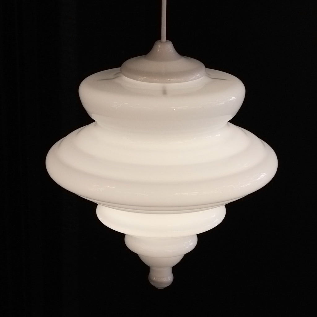 A vintage-style white glass pendant chandelier with a tiered design, suspended against a solid black background.