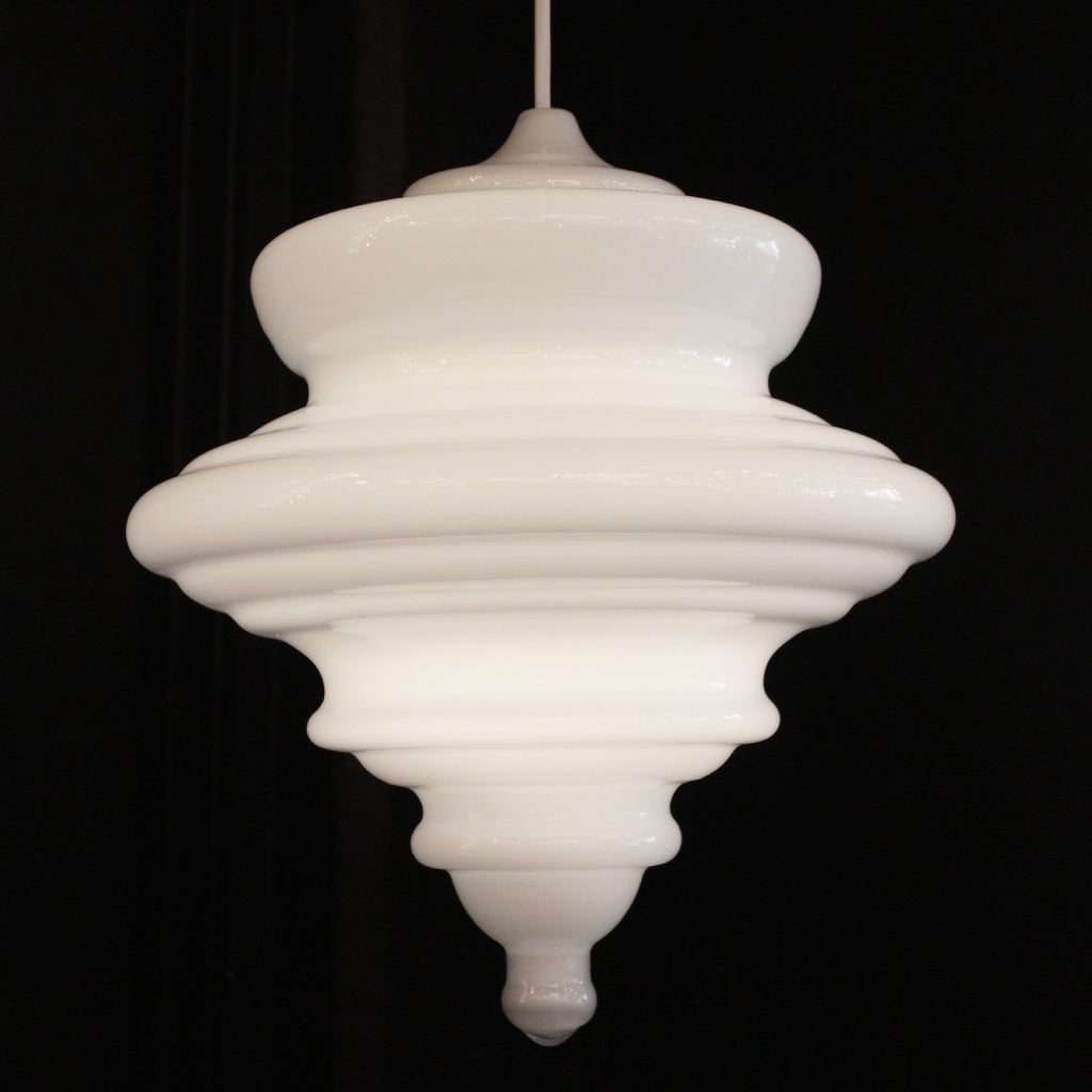 A white ribbed glass pendant light fixture with a tiered design, suspended against a solid black background.