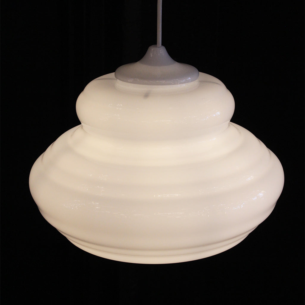 A vintage-style white ribbed glass pendant light with a matching white cord, shown against a solid black background.
