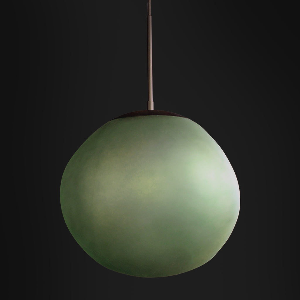 Green spherical pendant light against a black background