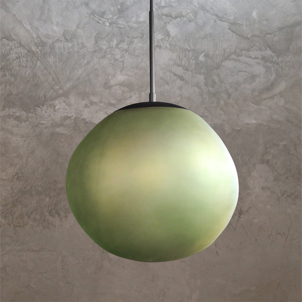 Green spherical pendant light against a textured gray wall
