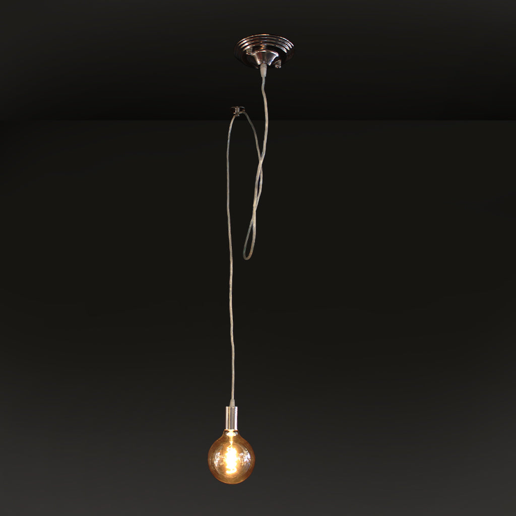 Silver pendant light with amber bulb against dark background