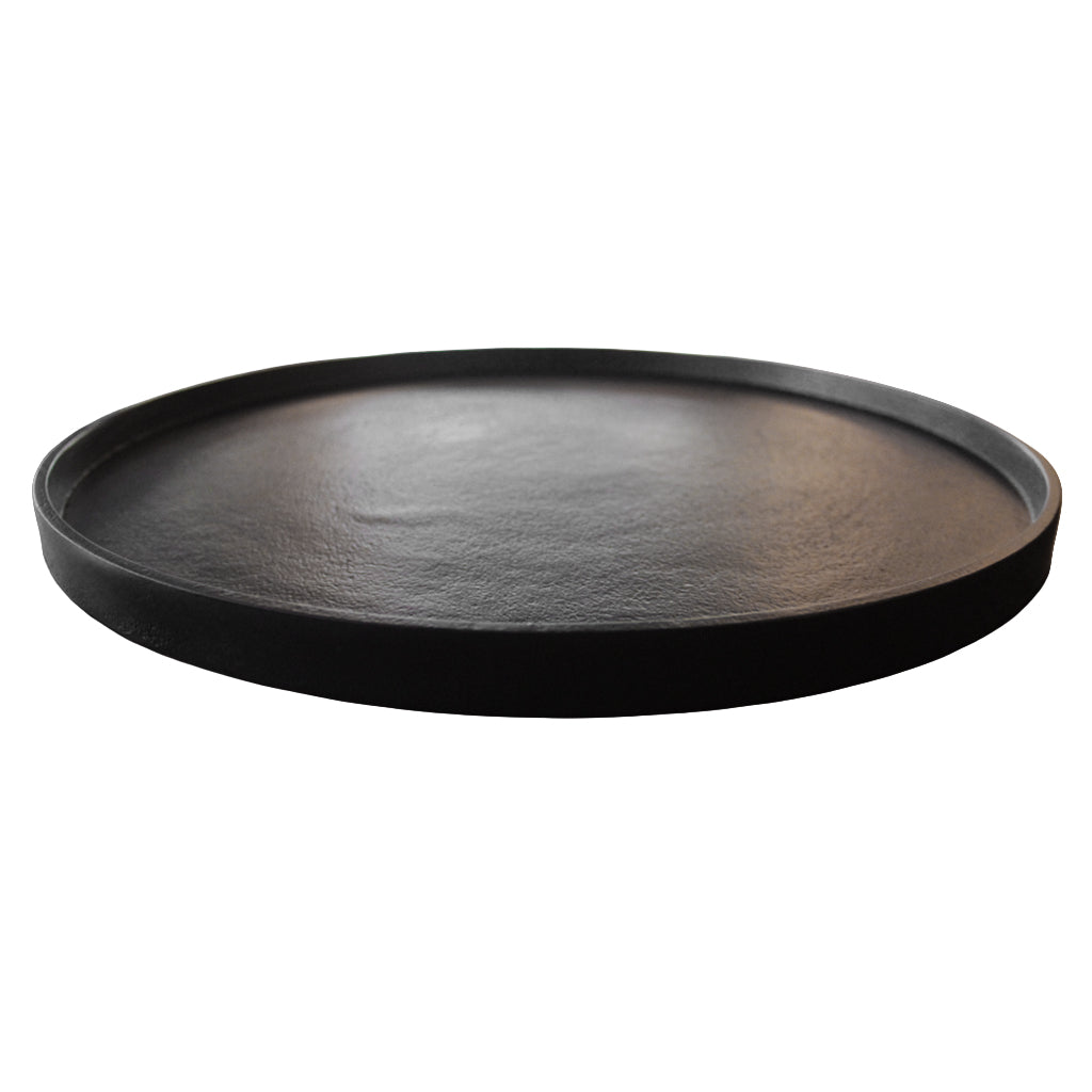 Black round tray on a wooden surface with a blurred background