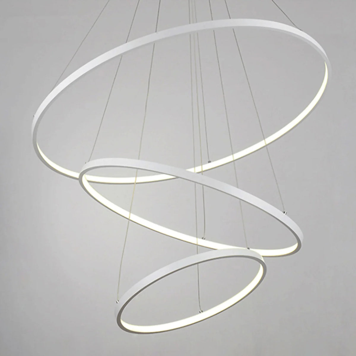Modern pendant light with three circular rings on a gray background