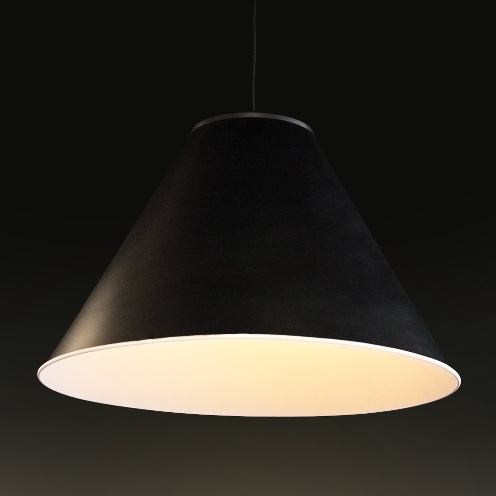 A black conical pendant lampshade with a warm white illuminated interior over a dining table