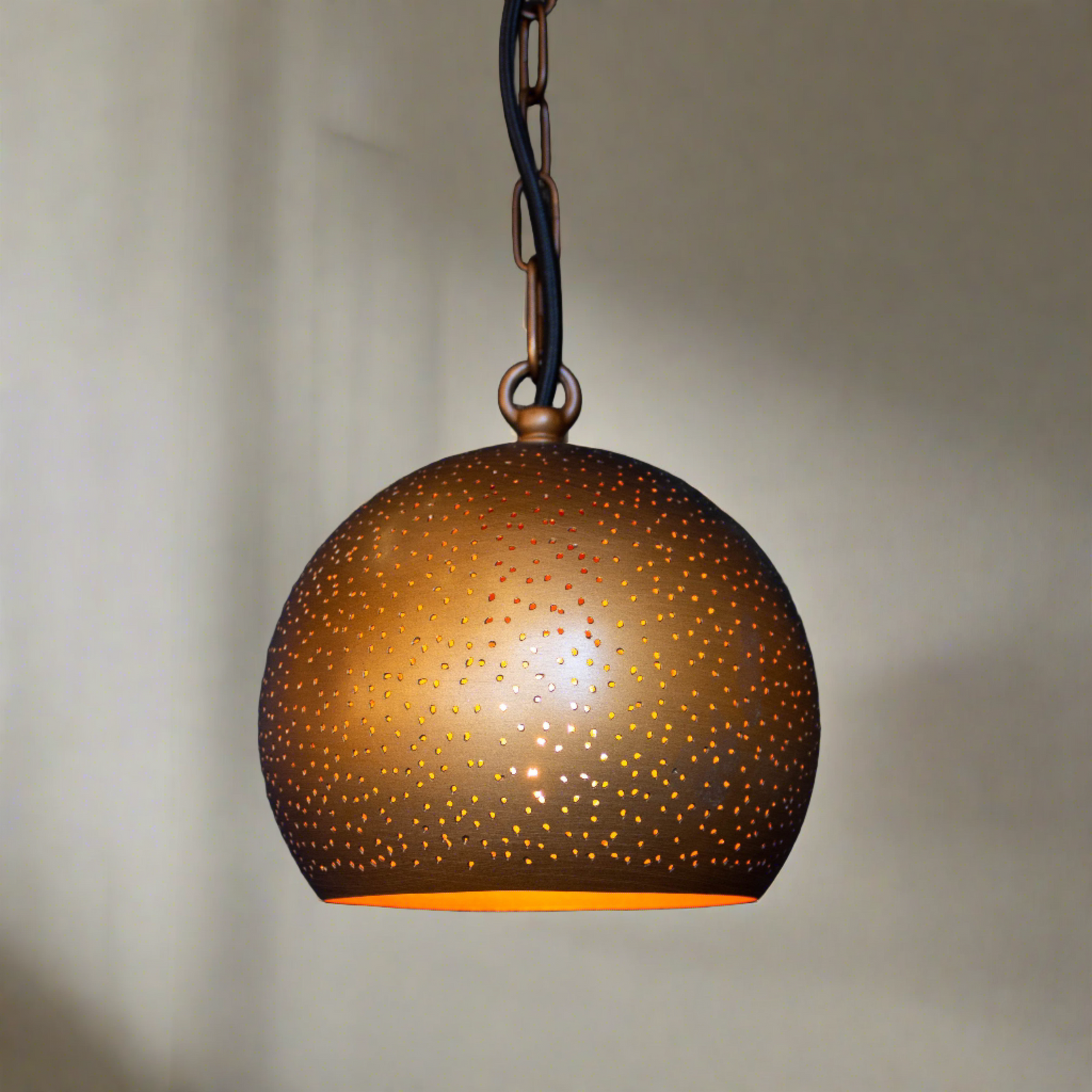 Bronze-colored pendant light with a textured surface on a gray background