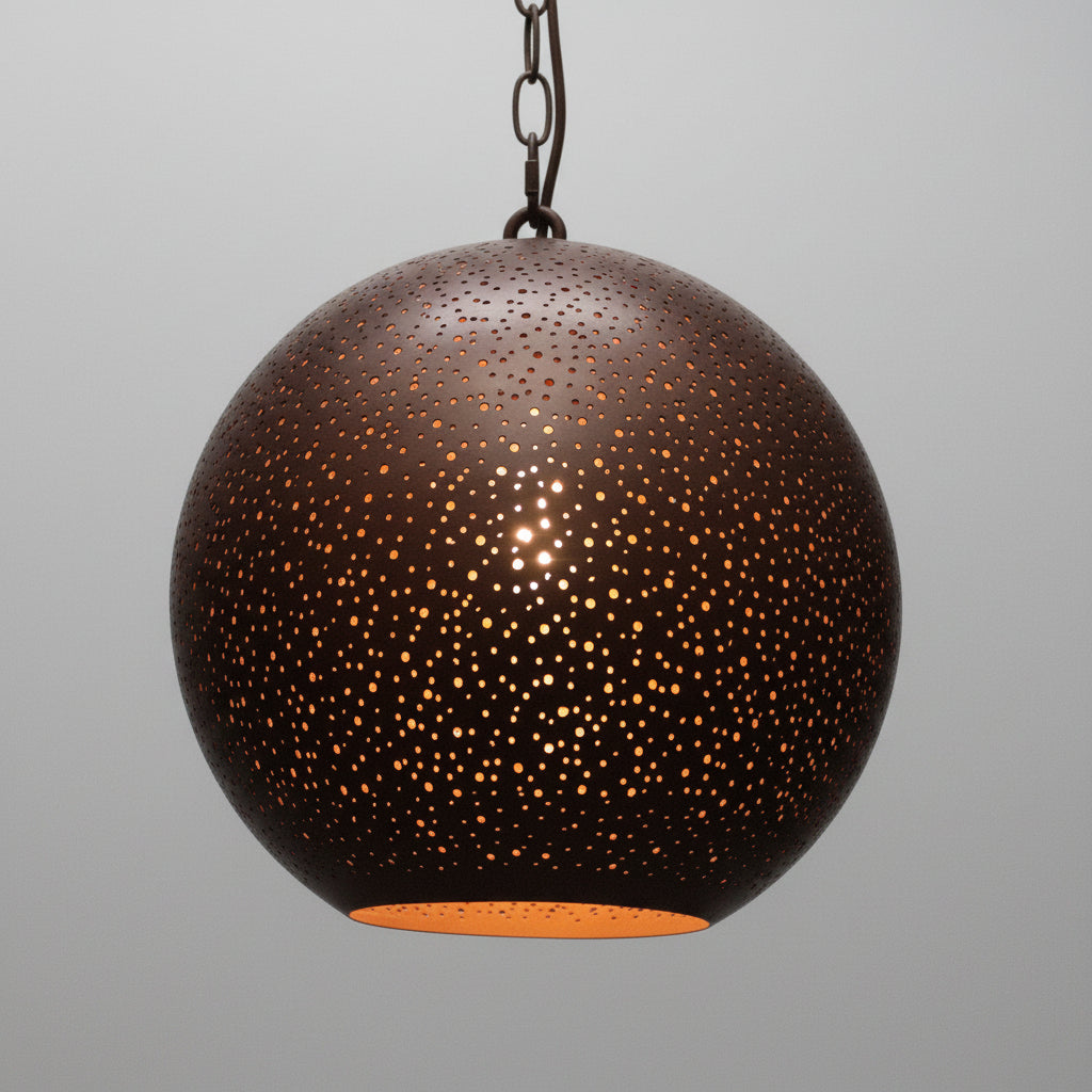 Spherical pendant light with perforated design on a gray background