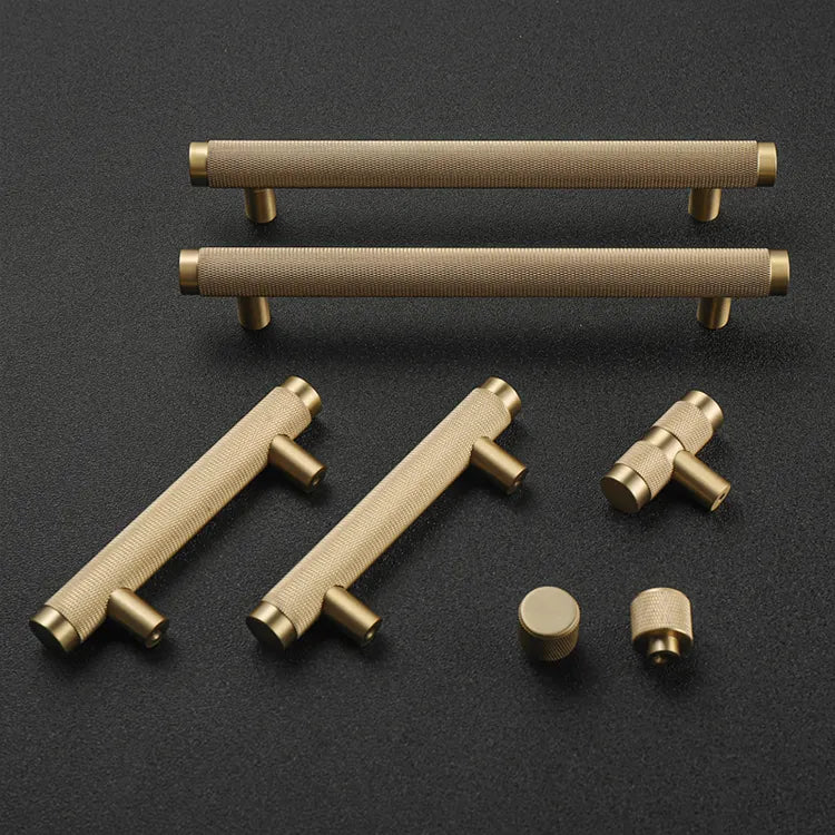 A solid brass T-pull cabinet handle against a white background